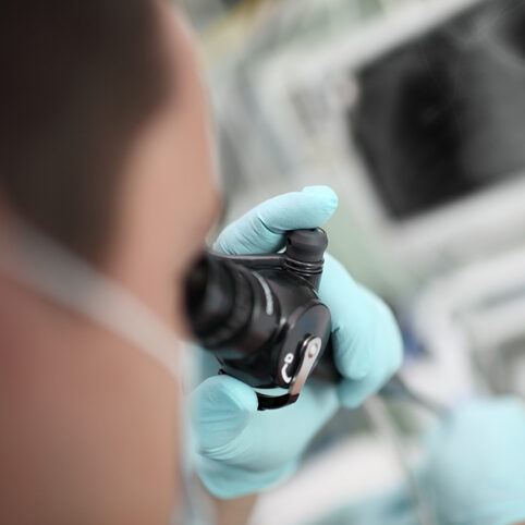Image of physician looking through microscope